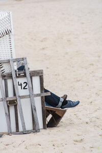 Germany, Mecklenburg-Western Pomerania, Usedom Island, Person in beach chair on the beach, close-up, detail Germany, Mecklenburg-Western Pomerania, Usedom Island, Person in beach chair on the beach, close-up, detail
