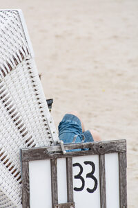 Germany, Mecklenburg-Western Pomerania, Usedom Island, Person in beach chair on the beach, close-up, detail Germany, Mecklenburg-Western Pomerania, Usedom Island, Person in beach chair on the beach, close-up, detail