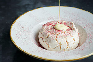 Meringue desert with custard being poured on top