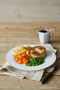 Pie and chips with vegetables and gravy