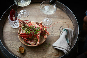 Dressed lobster ready to serve with glasses of champagne being poured