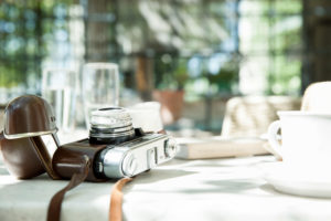 Camera and cup and saucer on table