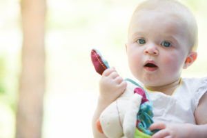 Baby holding stuffed toy, portrait