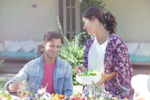 Wife serving salad to husband