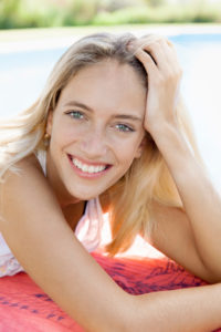 Woman relaxing at poolside, portrait