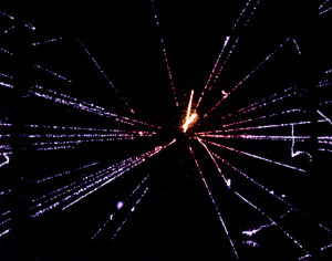 A proton-antiproton interaction at 540 GeV, showing particle tracks in a streamer chamber. The dark bands on each side are lead baffles, designed to generate cascades as particles pass through. Photo taken in 1982 at CERN