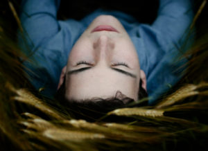Young man lying in the field with closed eyes Young man lying in the field with closed eyes