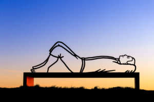 Lying man on a bench at sunset Lying man on a bench at sunset