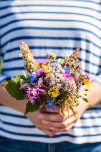 A young woman is holding a bouquet of freshly picked wildflowers, Europe, Denmark, Bornholm, A young woman is holding a bouquet of freshly picked wildflowers, Europe, Denmark, Bornholm,