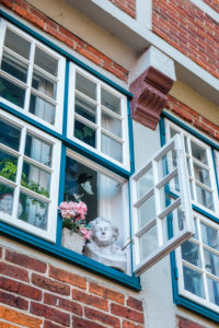 Europe, Germany, Lower Saxony, Otterndorf. Bust and roses in an open window of the former Latin school (1614). Europe, Germany, Lower Saxony, Otterndorf. Bust and roses in an open window of the former Latin school (1614).