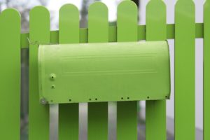 Green mailbox at pale green fence, Green mailbox at pale green fence,