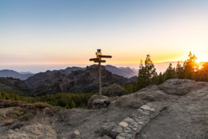 Signpost at the 'Roque Nublo' monolith plateau in the high mountains of Gran Canaria (1813 m altitude) at sunset, Spain Signpost at the 'Roque Nublo' monolith plateau in the high mountains of Gran Canaria (1813 m altitude) at sunset, Spain