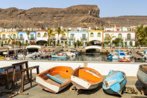 Old boats at the port of Puerto de Mogan overlooking promenade, southwest Gran Canaria, Spain Old boats at the port of Puerto de Mogan overlooking promenade, southwest Gran Canaria, Spain