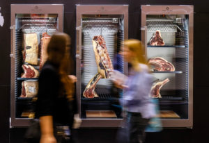 Trade fair visitors looking at steak meat Dry Aged Beef in the ripening cabinet, ANUGA food fair, Cologne, North Rhine-Westphalia, Germany Trade fair visitors looking at steak meat Dry Aged Beef in the ripening cabinet, ANUGA food fair, Cologne, North Rhine-Westphalia, Germany