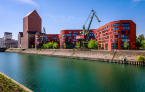 Inner harbor Duisburg with the wave-shaped new building of the North Rhine-Westphalia State Archive, the converted archive tower in the former RWSG storage building and old harbor cranes, Duisburg, Ruhr area, North Rhine-Westphalia, Germany Inner harbor Duisburg with the wave-shaped new building of the North Rhine-Westphalia State Archive, the converted archive tower in the former RWSG storage building and old harbor cranes, Duisburg, Ruhr area, North Rhine-Westphalia, Germany