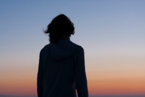 Rückansicht einer Frau im Sonnenuntergang Rückansicht einer Frau im Sonnenuntergang