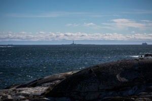 Blick auf Færder Fyr und zwei Fähren, blauer Himmel Blick auf Færder Fyr und zwei Fähren, blauer Himmel