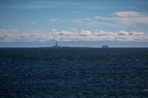 Blick auf Færder Fyr und eine Fähre, blauer Himmel Blick auf Færder Fyr und eine Fähre, blauer Himmel