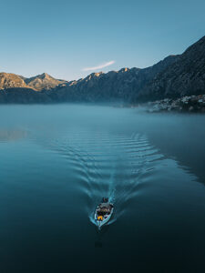 Bay of Kotor in Montenegro on the Adriatic Sea, sunrise, boat on the water in the morning mist