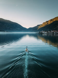 Bay of Kotor in Montenegro on the Adriatic Sea, sunrise, boat on the water in the morning mist