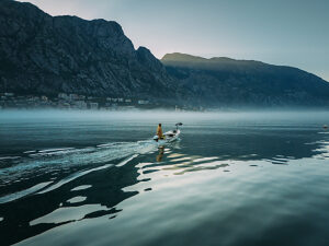Bay of Kotor in Montenegro on the Adriatic Sea, sunrise, boat on the water in the morning mist