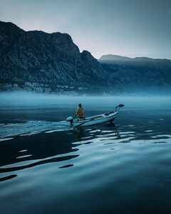 Bay of Kotor in Montenegro on the Adriatic Sea, sunrise, boat on the water in the morning mist
