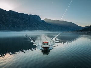 Bay of Kotor in Montenegro on the Adriatic Sea, sunrise, boat on the water in the morning mist