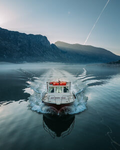 Bay of Kotor in Montenegro on the Adriatic Sea, sunrise, boat on the water in the morning mist