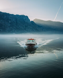 Bay of Kotor in Montenegro on the Adriatic Sea, sunrise, boat on the water in the morning mist
