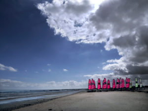 Eine Gruppe Strandsegler wartet auf den Einsatz. Die Sonne lässt die Segel erstrahlen Eine Gruppe Strandsegler wartet auf den Einsatz. Die Sonne lässt die Segel erstrahlen