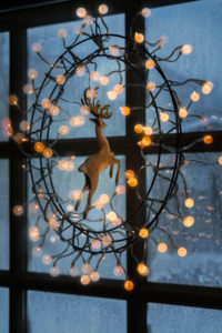 Christmas lights hanging on window indoors. Christmas lights hanging on window indoors.