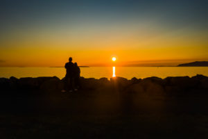Couple enjoying the sunset, Saebraut street, Reykjavik, Iceland Couple enjoying the sunset, Saebraut street, Reykjavik, Iceland