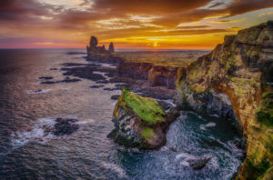 Londrangar sea stacks and the Thufubjarg cliffs. Londrangar are basalt volcanic dikes that were formed after magma solidified and after years of erosion these sea stacks remain, Snaefellnes Peninsula, Iceland 