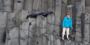 Teenagers on basalt columns at Reynisfjara, South Coast, Iceland
