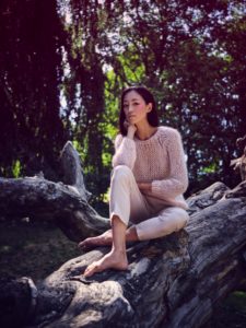 Young woman in nature between trees and tree trunks Young woman in nature between trees and tree trunks