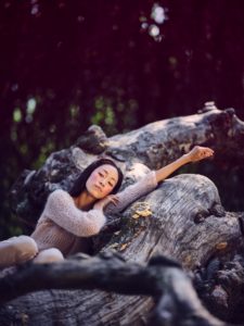 Young woman in nature between trees and tree trunks Young woman in nature between trees and tree trunks
