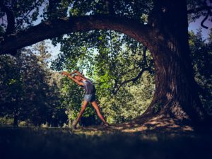 Young woman in nature between trees and tree trunks Young woman in nature between trees and tree trunks
