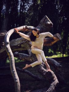 Young woman in nature between trees and tree trunks Young woman in nature between trees and tree trunks