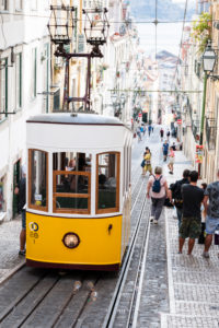 Paved narrow street canyon with tram, view down to the Tagus Paved narrow street canyon with tram, view down to the Tagus