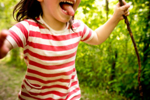 4-6 jähriges Kind mit Streifenhemd und Stock in der Hand rennt durch den Wald, Nahaufnahme, Detail, 4-6 jähriges Kind mit Streifenhemd und Stock in der Hand rennt durch den Wald, Nahaufnahme, Detail,