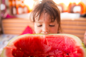 4-6 jähriges Kind schaut in ausgelöffelte Melonenschale im Wohnwagen 4-6 jähriges Kind schaut in ausgelöffelte Melonenschale im Wohnwagen