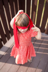 4-6 years old girl in red dress and red blindfold 4-6 years old girl in red dress and red blindfold