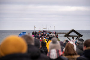 Deutschland, Mecklenburg-Vorpommern, Prerow, Hunderte Touristen stehen auf der Seebrücke und beobachten Hobbyschwimmer beim traditionellen Anbaden. Deutschland, Mecklenburg-Vorpommern, Prerow, Hunderte Touristen stehen auf der Seebrücke und beobachten Hobbyschwimmer beim traditionellen Anbaden.