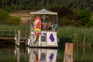 Deutschland, Mecklenburg-Vorpommern, Ostseebad Sellin, Seedorf, ein Motorschiff mit lila Kuhflecken liegt im Naturhafen. Deutschland, Mecklenburg-Vorpommern, Ostseebad Sellin, Seedorf, ein Motorschiff mit lila Kuhflecken liegt im Naturhafen.