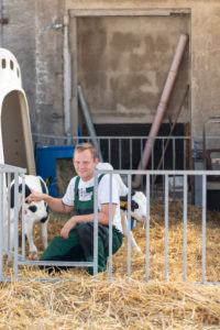 Landwirt, Bauer, streichelt eine Kälbchen Landwirt, Bauer, streichelt eine Kälbchen