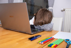 Junge sitzt im Homeschooling vor einem Laptop Junge sitzt im Homeschooling vor einem Laptop