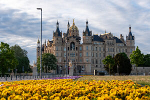 Schwerin Castle, magnificent facade, golden dome, equestrian statue, colorful flower bed in the foreground, spring, Schwerin, Mecklenburg-Western Pomerania, Germany