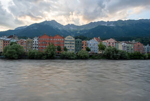 Colorful houses on the Inn River against an Alpine backdrop in Innsbruck, Austria