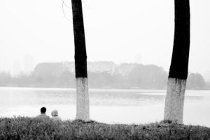 A couple is sitting at a lake in Xuanwuhu Park in China