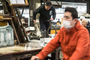 A worker at the fish market in Tokyo cuts a block of ice